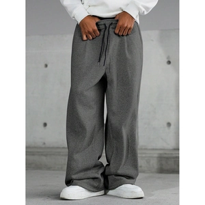 Detail view of dark grey joggers featuring elastic waistband and black drawstrings