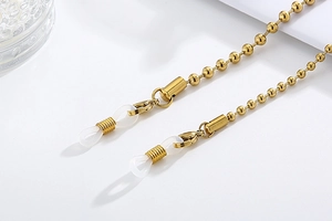 Macro shot of gold beaded sunglasses chain with white silicone anti-slip loops