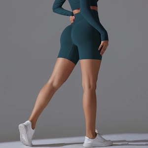 Close-up of high-waisted seamless peach lift yoga shorts in deep teal performance fabric
