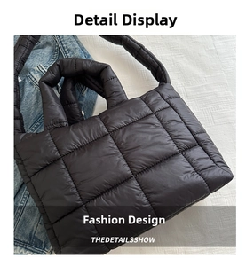 Close-up of black quilted puffer tote bag with glossy finish and shoulder strap detail