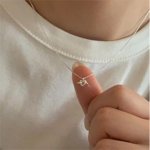 Minimalist 925 sterling silver knot heart key pendant necklace worn on a neck