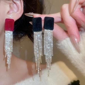 Dettagli di orecchini quadrati in velluto con nappine di strass in rosso e nero