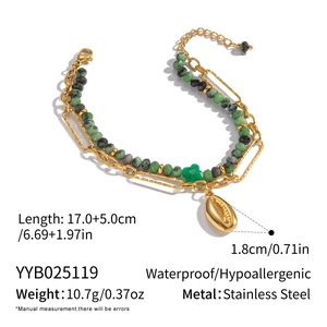 Detail of double-layer stainless steel bracelet with green stones and shell pendant