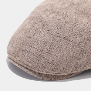 Primo piano della coppola in cotone beige che mostra la trama del tessuto e le cuciture