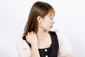 Model wearing silver letter S necklace and rhinestone stud earrings set in stainless steel