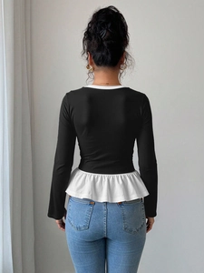 Camiseta ajustada negra de manga larga con volantes blancos y diseño de dos piezas