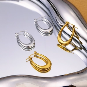 Boucles d'oreilles en U en acier inoxydable doré et argenté sur plateau miroir