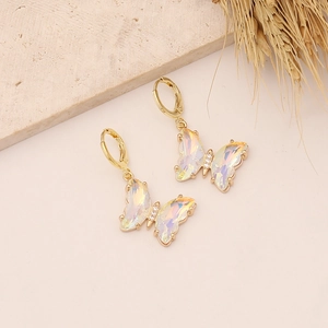 Macro detail of 18K gold butterfly hoop earrings with iridescent opal-like wings and zircons