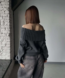 Back view of dark grey off-shoulder knit sweater showing drape and minimalist cut