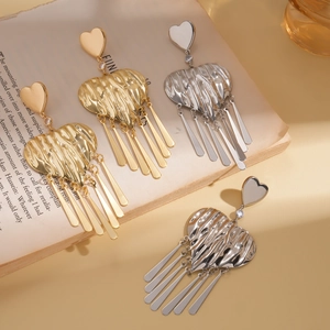 Statement metallic heart tassel earrings in gold and silver finish on vintage book