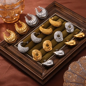 Selezione di orecchini vintage in oro e argento su un vassoio di velluto verde scuro
