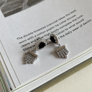 Detail of 925 silver earrings with black pear-shaped stone and micro-pave rectangle drop