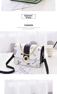 Dettaglio della stampa a cartoni su borsa in pelle bianca con catena dorata