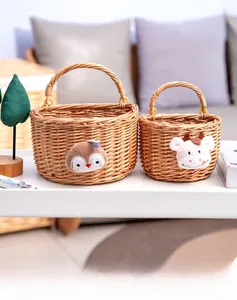 Detail view of two hand-woven wicker baskets with cute owl and calf animal patches