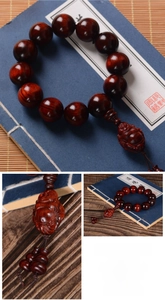 Macro detail of red sandalwood beads and carved Maitreya Buddha pendant on classic wooden beads
