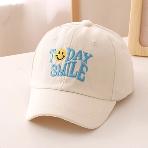 Detail-Stickerei von Today Smile Text und gelbem Gesicht auf cremefarbener Baumwollkappe