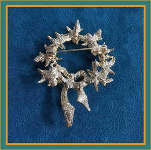 Detail of the golden metal back and secure safety pin buckle on the wreath brooch