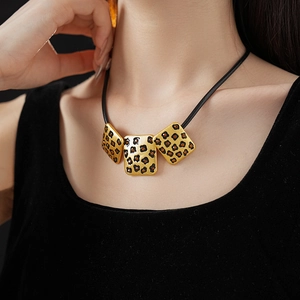 Close-up of vintage leopard print square pendant necklace worn on neck