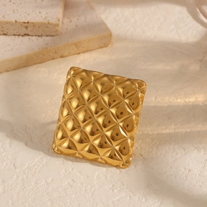Detail of golden adjustable ring with a quilted texture and elegant square floral design