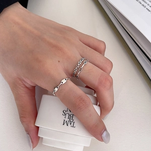 Detailed view of silver coffee bean link stackable rings on fingers for women