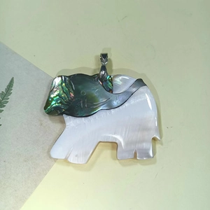 Macro detail of elephant shell pendant featuring colorful abalone and white mother of pearl