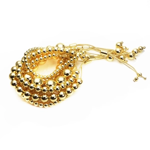 Detailed macro view of gold-plated multi-layer round bead bracelet with adjustable cord