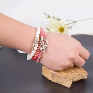 Close-up of bohemian beaded bracelet set with tree of life and leaf charms
