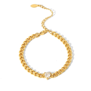 Macro detail of 18K gold-plated curb chain bracelet featuring a heart-shaped zircon stone