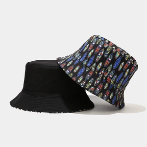 Reversible bucket hat with cartoon surfboard print and solid black cotton canvas fabric