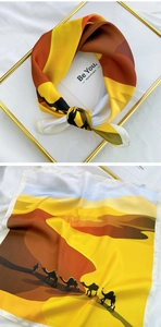 Detail of silk square scarf featuring camel desert print and smooth satin texture