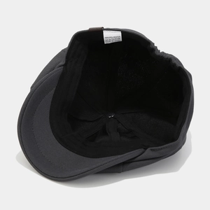 Vintage dark grey newsboy cap for men and women showing detailed interior lining structure
