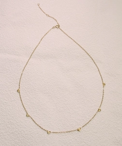 Detailed view of the gold heart pendant necklace with radiant laser-cut textures