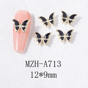 Détail macro de charmes d'ongles papillon noir avec cadre doré, taille 12x9mm