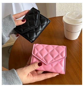Detail of classic quilted clutch wallets in black and pink with elegant diamond stitching