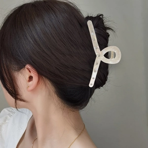 Elegant white marble acetate hair claw clip with rhinestones shown on model side profile