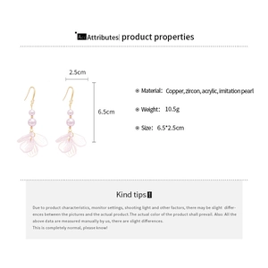 Detail view of purple acrylic petal earrings with imitation pearls and gold copper hooks