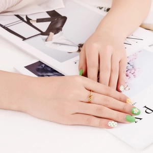 Close-up of a gold knot ring on model's finger with a minimalist and fashionable design