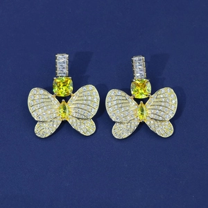Macro detail of butterfly earrings featuring yellow cushion-cut crystals and white pave stones