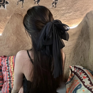 Oversized black organza bow hair claw clip with long streamers on female model