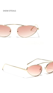 Detail view of cat eye sunglasses with golden metal frames and gradient pink lenses
