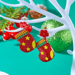 Detail of red glittery Christmas stocking earrings hanging on a white decorative display