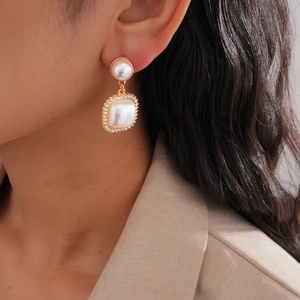Detailed view of elegant baroque pearl earrings with rhinestones and gold accents