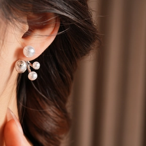 Macro view of crystal and pearl floral earrings worn on a model with elegant lighting