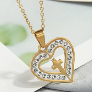 Close-up of golden double heart pendant with cross and white crystal embellishments