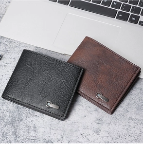Close-up of black and dark brown leather bi-fold wallets with textured metal buckle finish