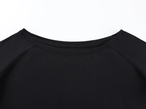 Close-up of neckline stitching and high-quality knit texture on a black off-shoulder top