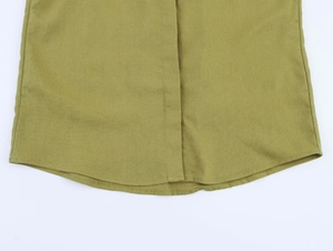 Detailed view of olive green linen shirt hem with precise stitching and curved cut
