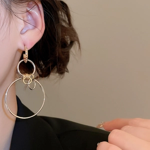 Detail shot of oversized mixed metal geometric hoop earrings worn by a model