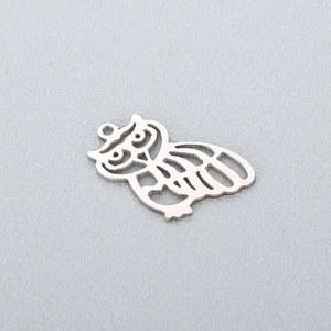 Detailed macro view of a hollowed-out owl pendant in polished silver stainless steel