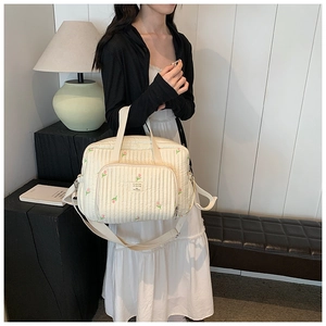 Détail du sac à langer matelassé en coton avec broderies de tulipes roses